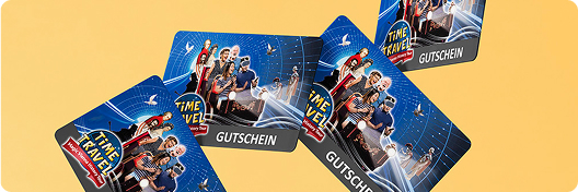 Four gift cards on the theme of "Time travel" with illustrated figures in futuristic clothing on a blue and black background. The words "GIFT VOUCHER" are printed on each card. The cards are arranged on a yellow background.