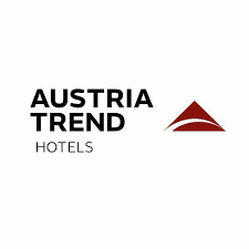Logo der Austria Trend Hotels mit schwarzem Text auf weißem Hintergrund. Neben dem Text befindet sich eine stilisierte rote Dreiecksform mit einem geschwungenen Ausschnitt.