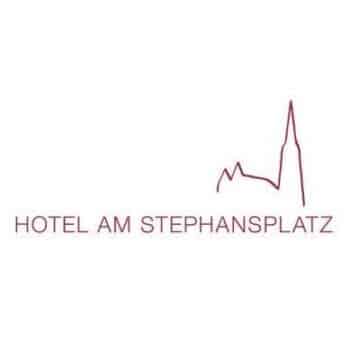 Logo per "Hotel Am Stephansplatz" con il profilo rosso minimalista di un edificio con un'alta torre sopra il testo.