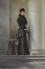 Eine Frau in einem langen schwarzen Kleid steht neben einem großen Hund vor hohen weißen Säulen und blickt den Betrachter direkt an. Die Szene strahlt eine klassische und elegante Atmosphäre aus.